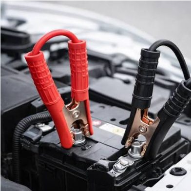 Jumper cables connected to a car battery for a jump start